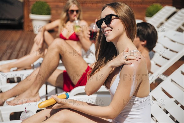 Woman smiling putting sunscreen her arm