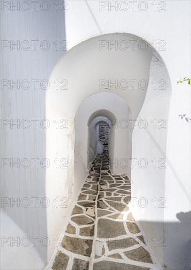 Narrow alley with white archways