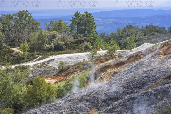 Steam rises from colourful rubble heaps