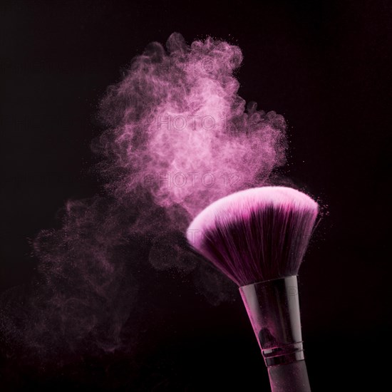 Bright dust powder brush makeup black background