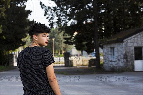 Young man looking back urban environment