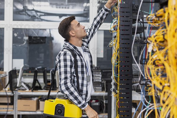 Young network engineer with box looking ethernet switches