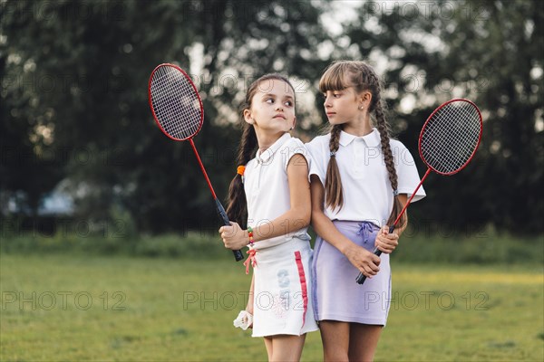 Angry girls holding badminton hand looking each other