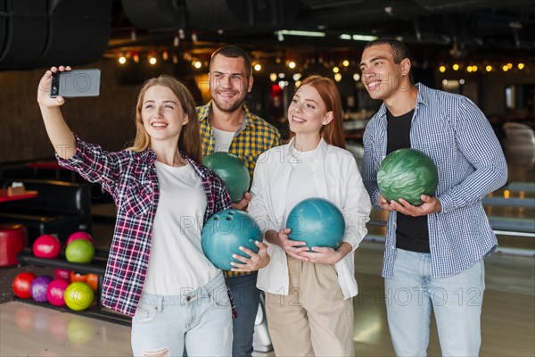 Friends holding colorful bowling balls