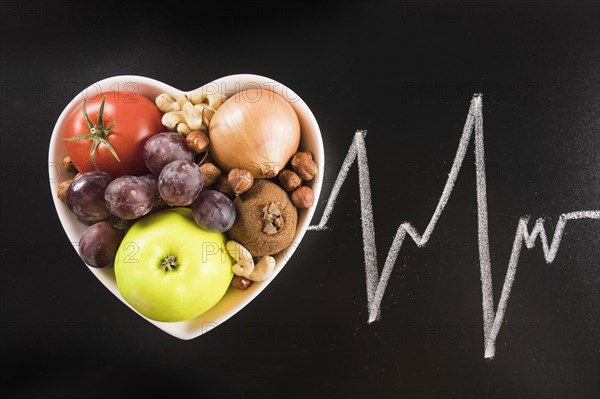 Healthy food heart shape container with chalk drawn heart pulse blackboard