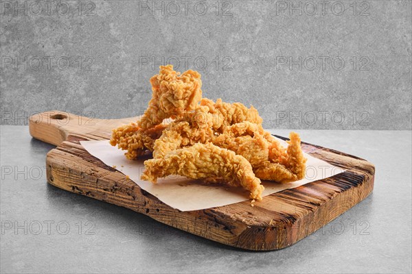 Deep fried chicken nuggets in breading on parchment paper