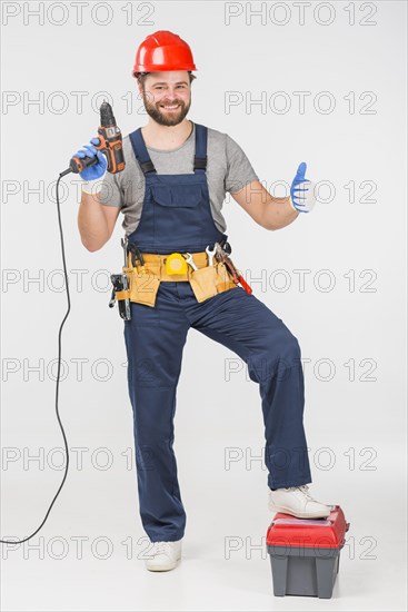 Repairman with drill showing thumb up