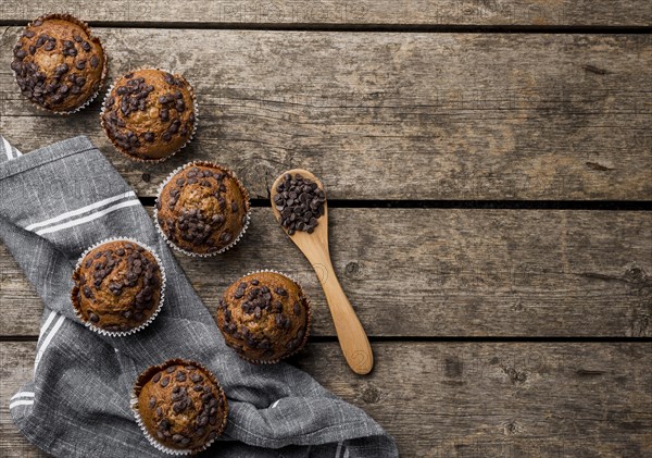 Top view delicious arrangement muffins wooden background