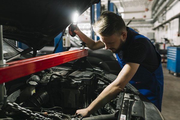 Auto mechanic looking car s engine room