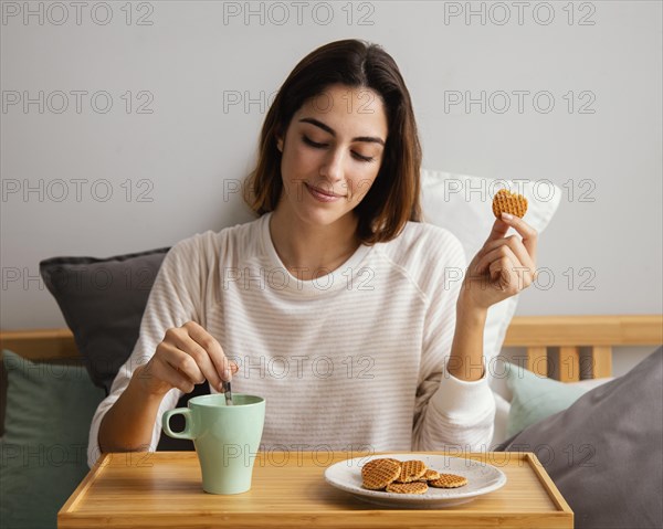 Front view woman eating having coffee home
