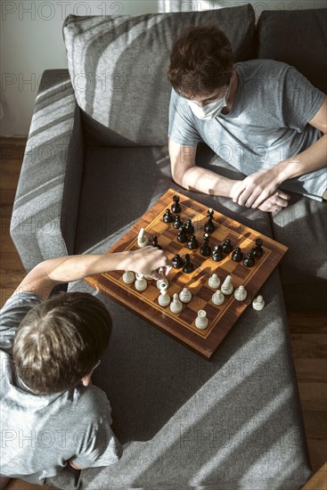 High angle quarantined boys playing chess