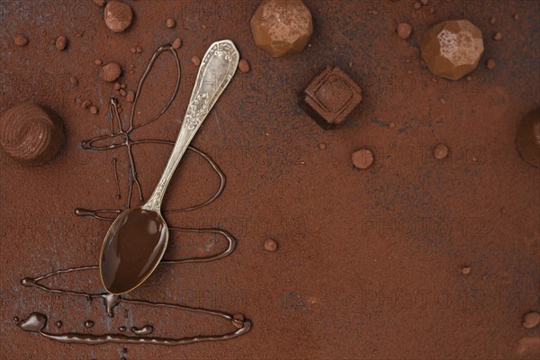 Spoon with chocolate syrup truffles cocoa powder