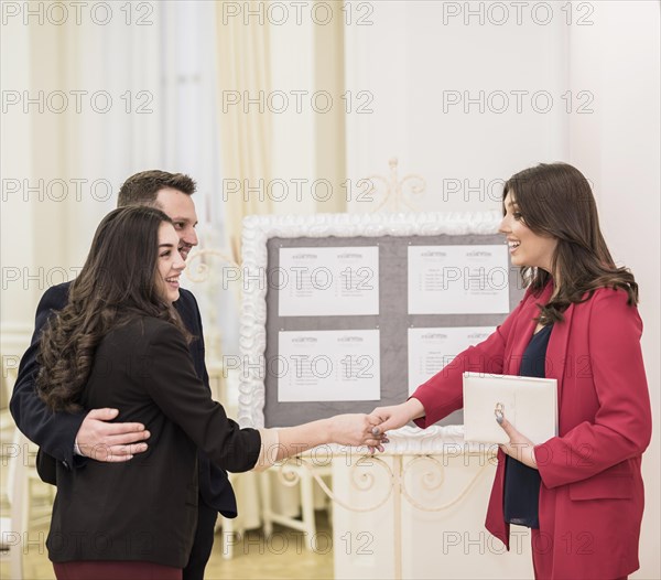 Young couple event manager shaking hands