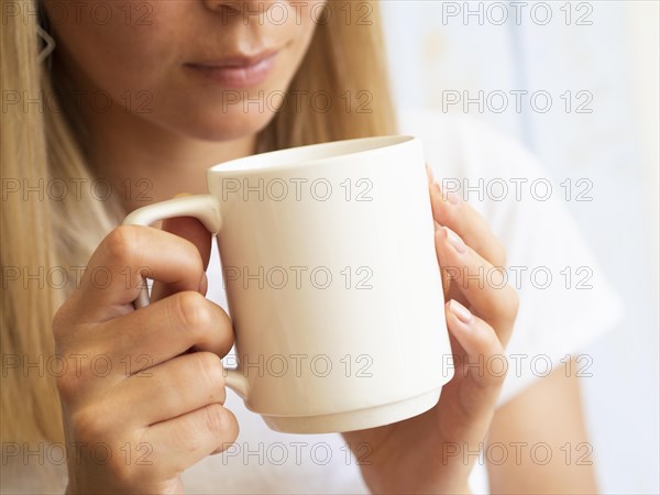 Young woman holding white cup
