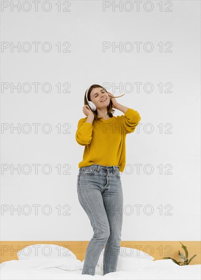 Full shot woman standing bed