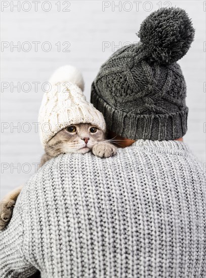 Man with back holding small kitten