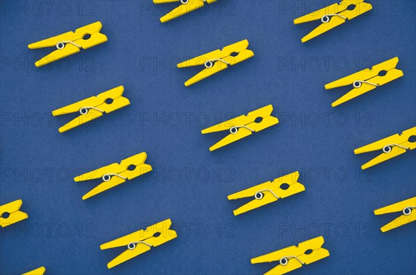 Flat lay yellow clothes pins blue background