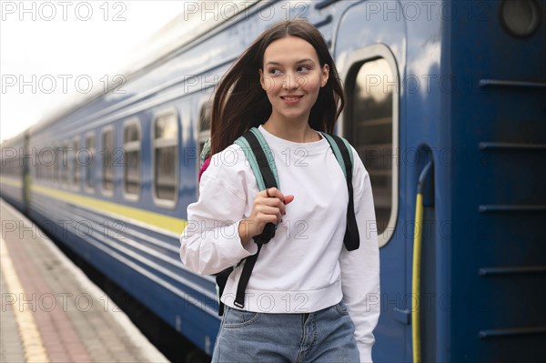 Girl standing train with her backpack