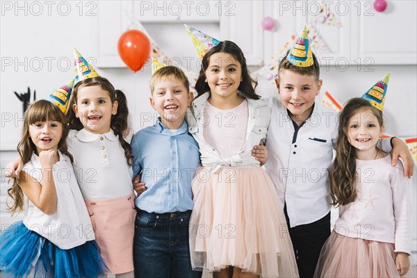 Portrait happy friends wearing party hat standing together