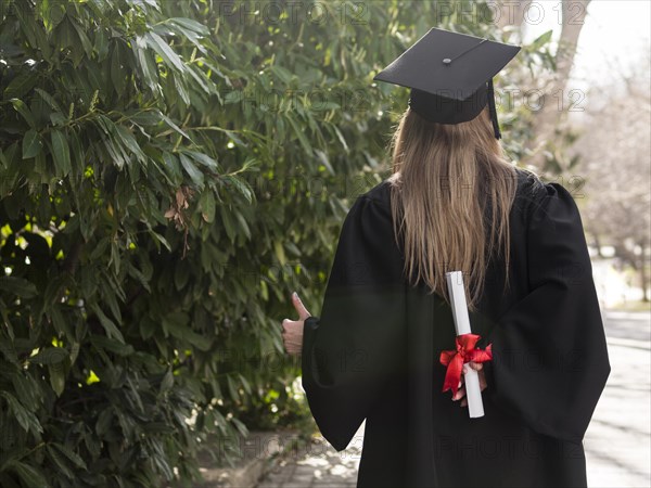 Back view woman holding her diploma