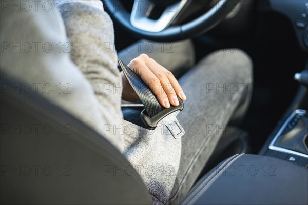 Businesswoman putting seat belt car