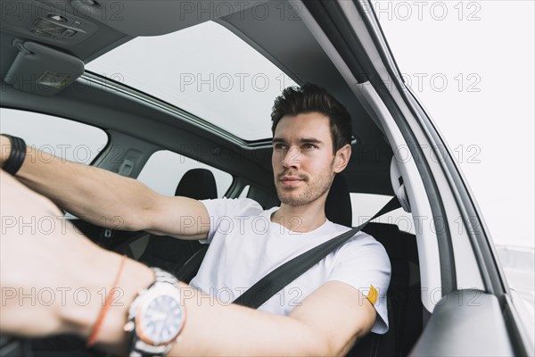 Close up young man driving car