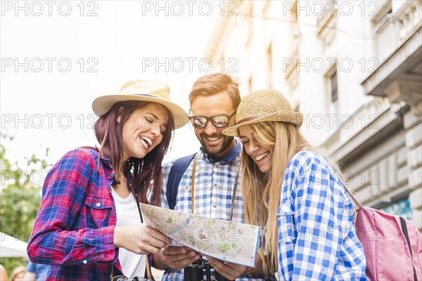 Group happy male female hikers looking location map