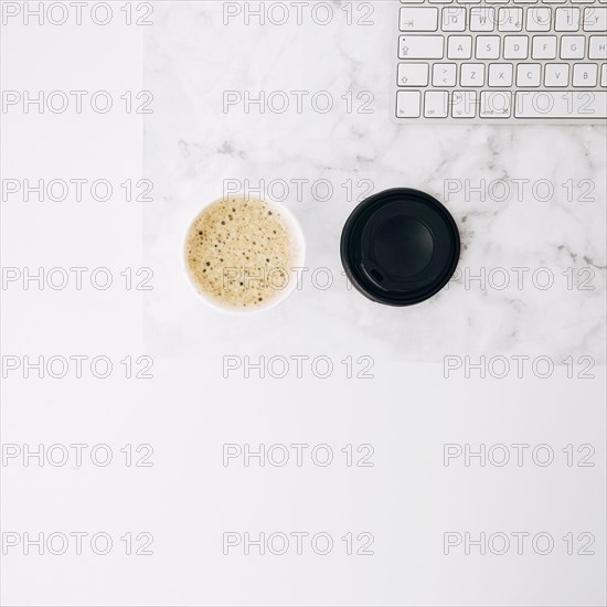 Overhead view coffee disposable takeaway coffee cup keyboard white desk