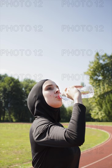 Woman drinking water from plastic bottle