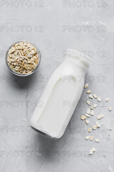 Flat lay milk bottle with oats