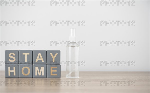 Front view wooden cubes with stay home hand sanitizer