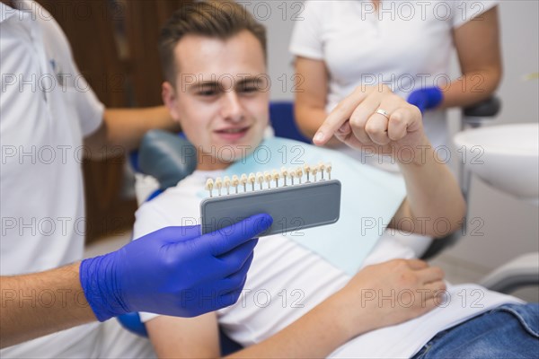 Patient pointing teeth with dentist