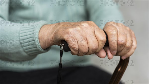 Older woman holding cane hands