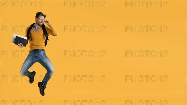 Young man with book jumping