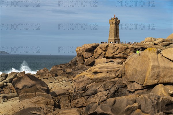 The rocks of the pink granite coast Cote de Granit Rose and the lighthouse Phare de Ploumanac'h near Ploumanac'h