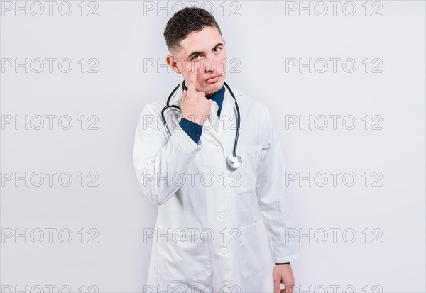 Serious doctor making gesture of watching you. Doctor making gesture of watching you. Concept of doctor with surveillance gesture