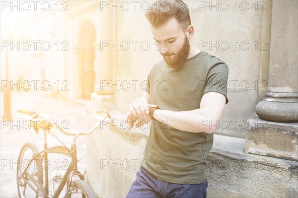 Male cyclist looking time wrist watch