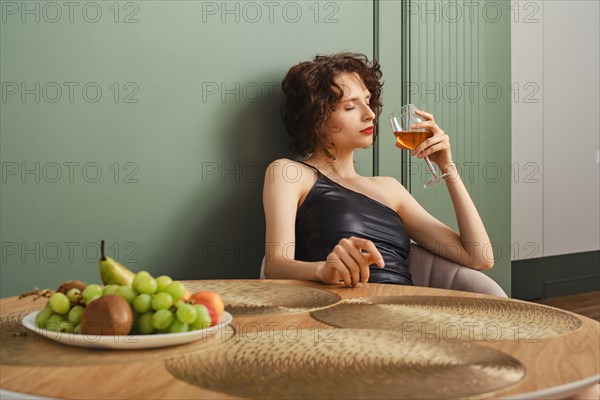 Elegant woman inhales aroma of wine she brought back from her trip
