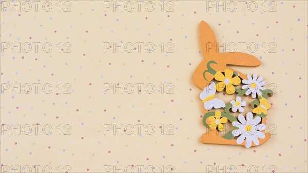 Wooden rabbit with flowers beige table