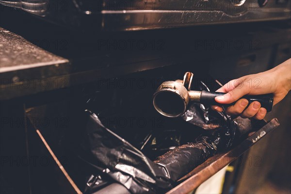 Crop hand throwing out coffee