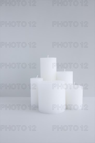 Close up white candles against grey background