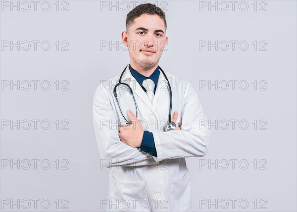 Portrait of handsome doctor with arms crossed isolated. Latin doctor with crossed arms on white background