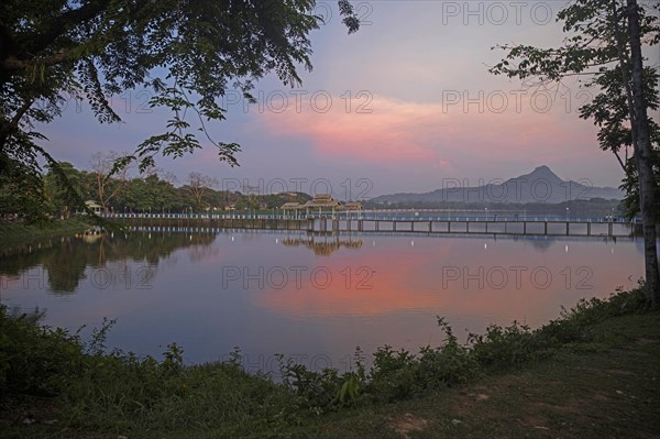 Wooden bridge over Kan Thar Yar Lake at sunset