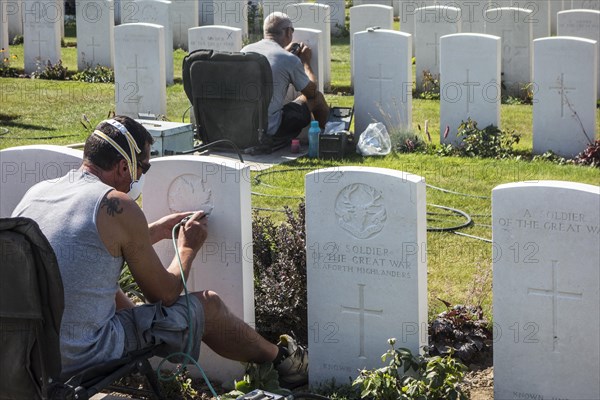 Engravers re-engraving headstones at the Tyne Cot Cemetery