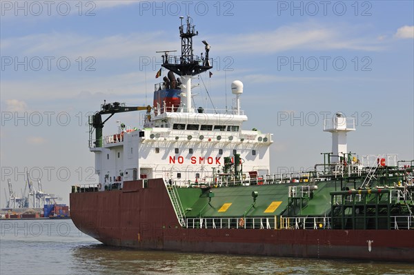 Red gas tanker sailing into dock of the Antwerp harbour