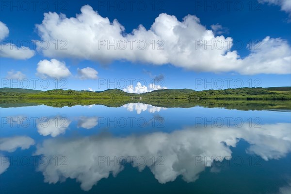 Reflection of clouds Altocumulus in front of blue sky reflected over in Pacific Still ocean without any waves with in mirror smooth sea surface water surface mirror smooth sea