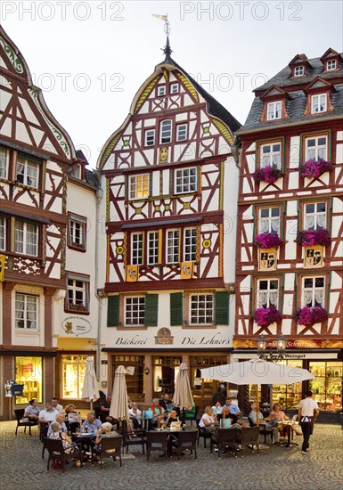 Gabled half-timbered houses on the busy medieval market square in the evening