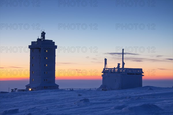 The Brocken weather station on the Brocken in the snow in winter at sunset