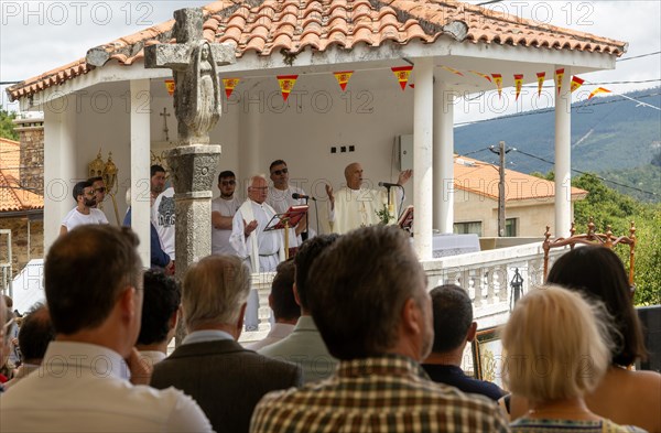 Village fiesta Catholic priest praying at outdoor mass service