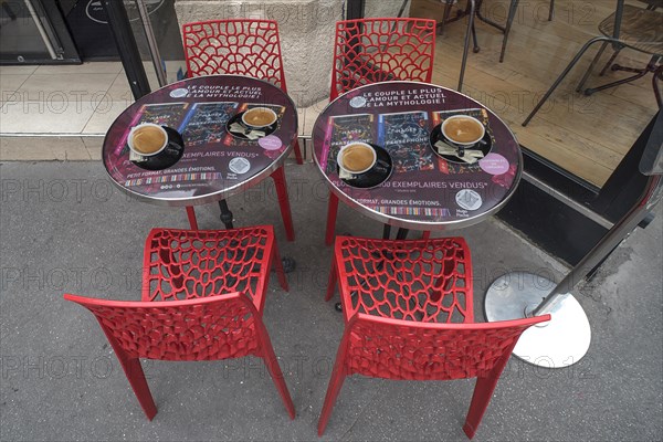 Espressos on bistro tables in front of a cafe